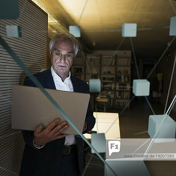 Digital composite image of businessman using laptop in office