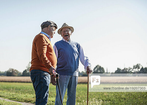 Two old friends standing in the fields  talking about old times