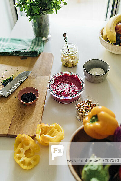 Schüssel Rote-Bete-Hummus mit Zutaten auf dem Tisch in der heimischen Küche