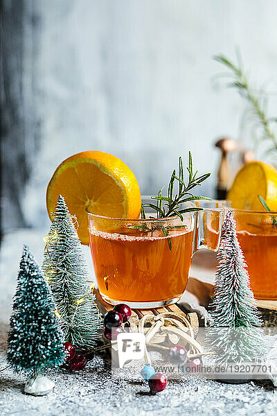 Cups of aperitif with Christmas tree models on table
