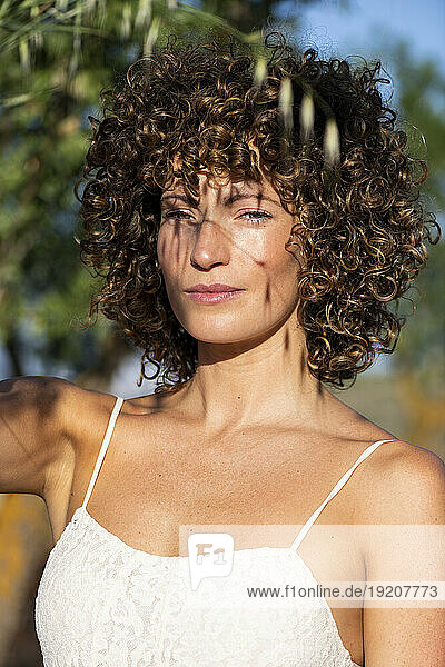 Beautiful woman with curly hair at sunny day