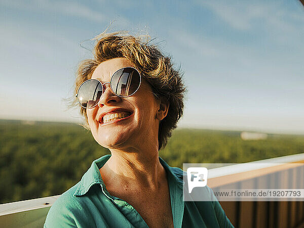 Smiling woman wearing sunglasses at sunny day