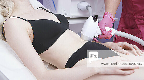 Client getting body hair removal treatment at clinic