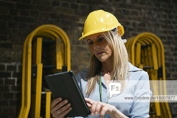 Blond engineer using tablet PC at factory