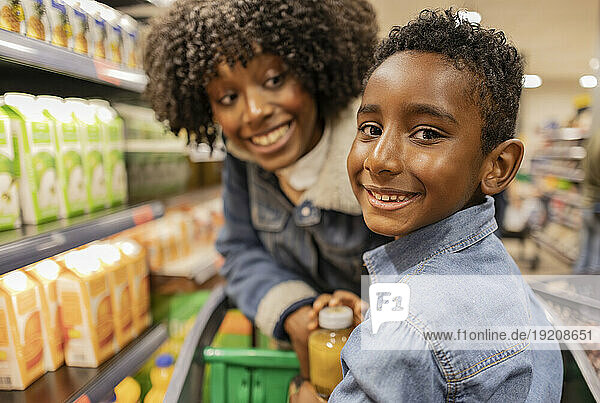 Happy boy with mother in supermarket