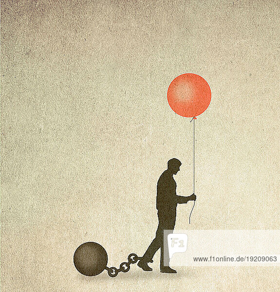 Silhouette of man restrained by ball and chain holding balloon symbolizing hope
