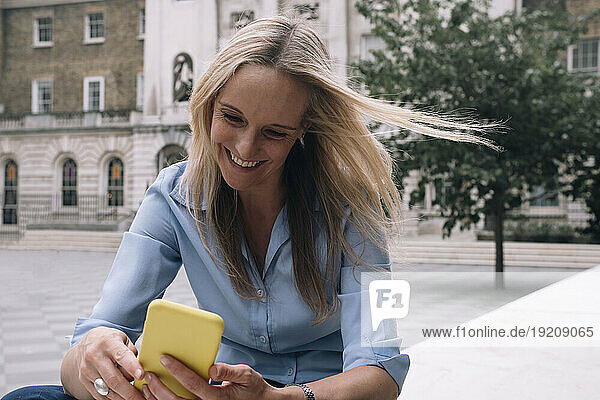Happy businesswoman surfing net through smart phone