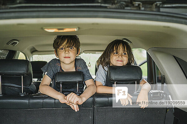 Smiling boys spending leisure time in car
