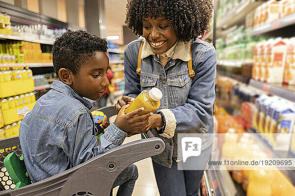 Happy mother shopping with son in supermarket