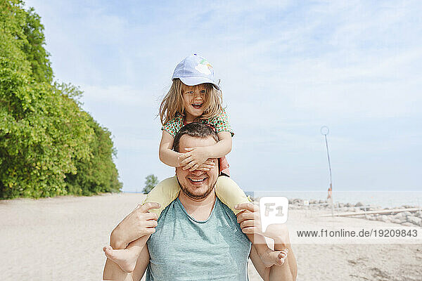 Happy father and daughter having fun at beach