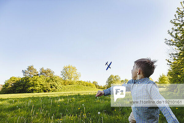 Boy playing with toy airplane in garden