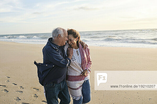 Loving senior couple together having fun at beach