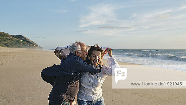 Cheerful senior couple having fun at beach