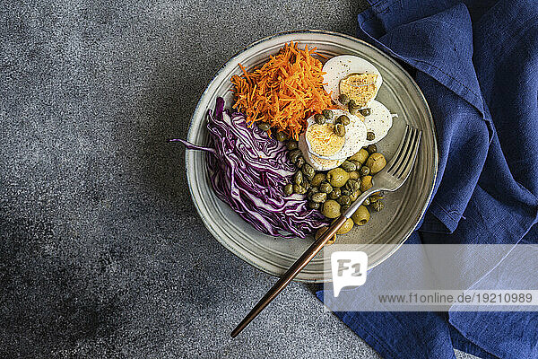 Bowl with boiled eggs  capers  olives  red cabbage and carrots (keto cuisine)