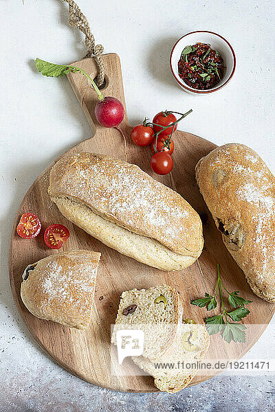 Baguette with dried tomatoes and green and black olives
