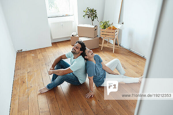 Happy couple sitting on floor at home
