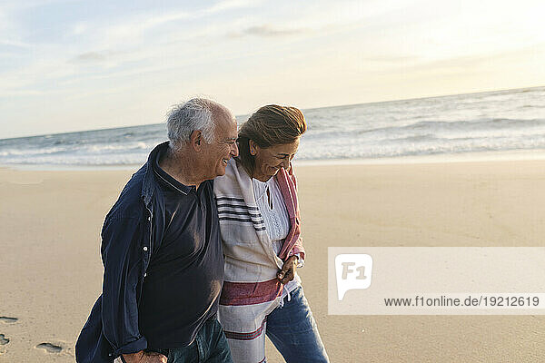 Happy senior couple together walking at beach
