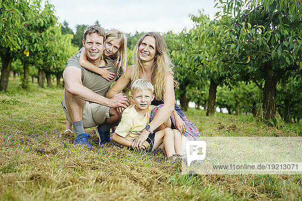 Happy family together admist cherry trees in garden