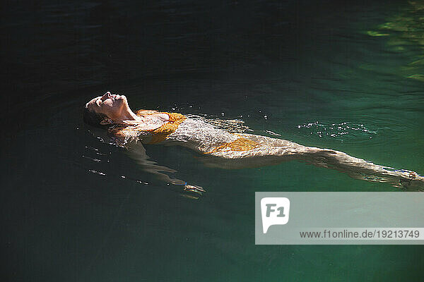 Woman floating on water in river