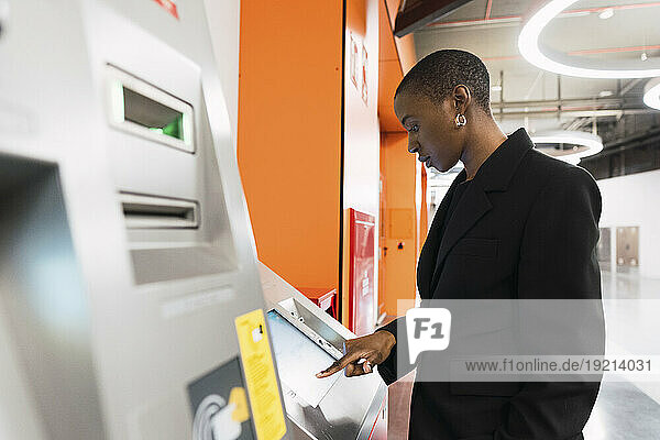 Young woman using ticket machine at underground metro station