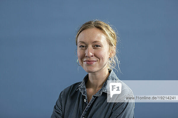 Happy blond woman against blue background