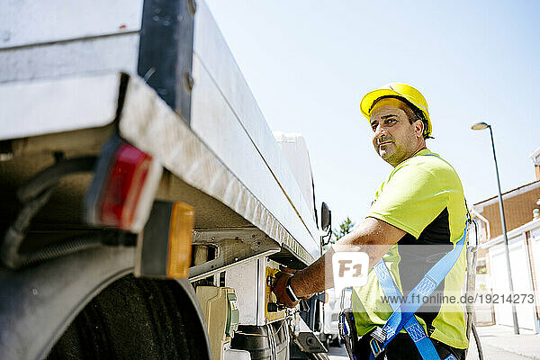 Engineer standing by truck on sunny day