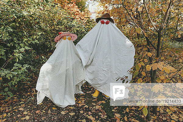Playful girls in white color costumes standing in garden