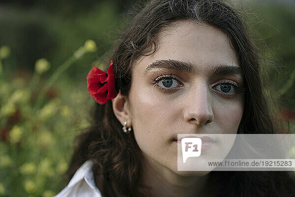 Young woman with poppy flower in hair