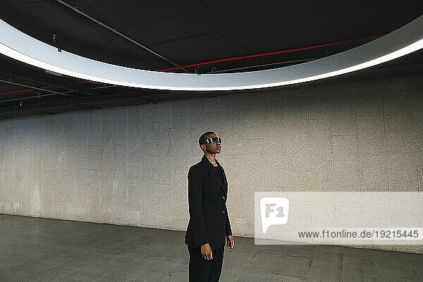 Young woman using futuristic glasses in parking garage