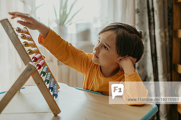 Boy learning abacus at home