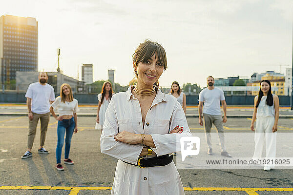 Happy woman standing with friends in background on road