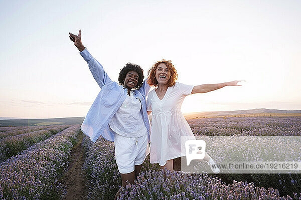 Smiling friends enjoying amidst lavender field