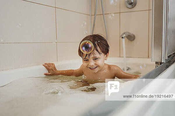 Happy boy bathing in bathtub