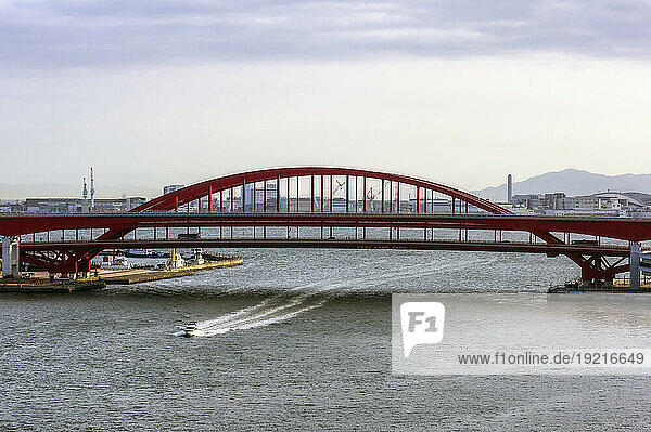 Japan  Hyogo Prefecture  Kobe  Motorboat sailing under Kobe Bridge