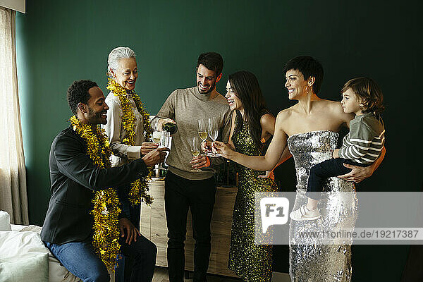 Multi-ethnic family toasting champagne glasses at home