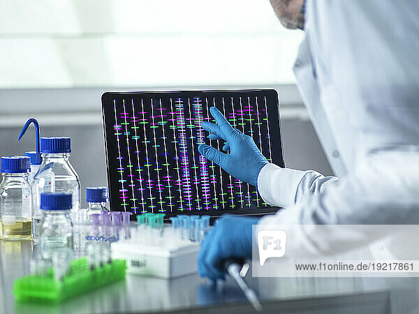 Scientist using laptop for genetic research in laboratory