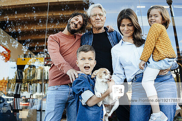 Happy family with pet in front of wall