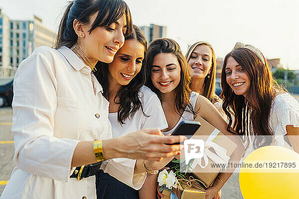 Happy woman using smart phone with friends