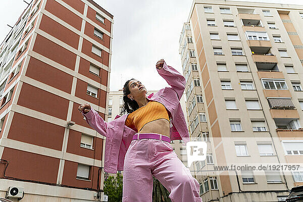 Fashionable woman dancing in front of building
