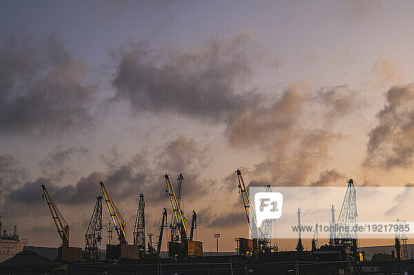 Bulgaria  Varna  Clouds over harbor cranes at dusk