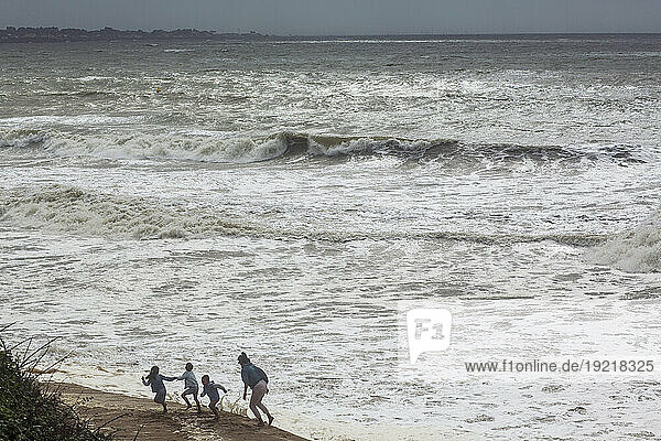 France  Tharon-Plage  Saint Michel Chef Chef  44  a woman and three children playing by the sea during the storm of August 2  2023.