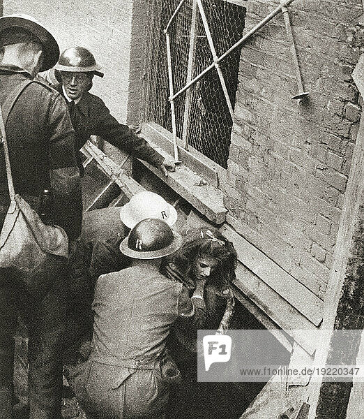 The victim of a daylight bombing raid on central London  October  1940 during WWII is lifted from a shattered basement. From Front Line 1940-41  published 1942