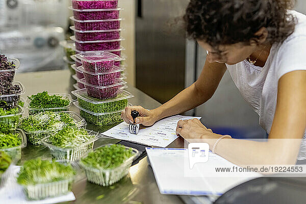Worker packaging microgreens in containers for shipping; Edmonton  Alberta  Canada