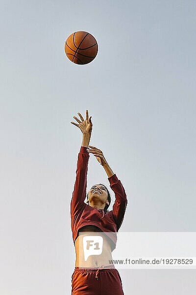 Junge Frau spielt Basketball