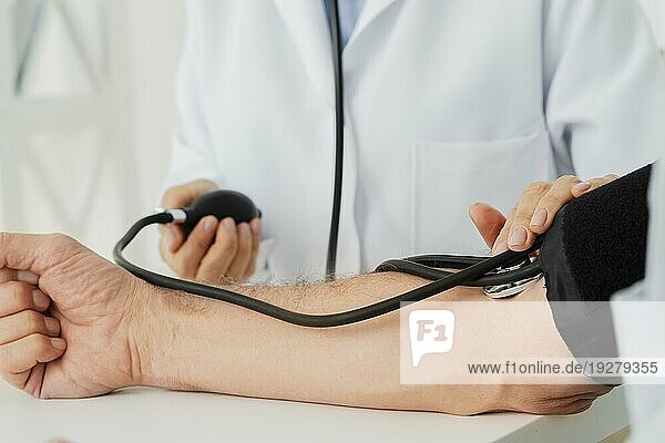 Nahaufnahme: Arzt bläst Blutdruckmanschette auf