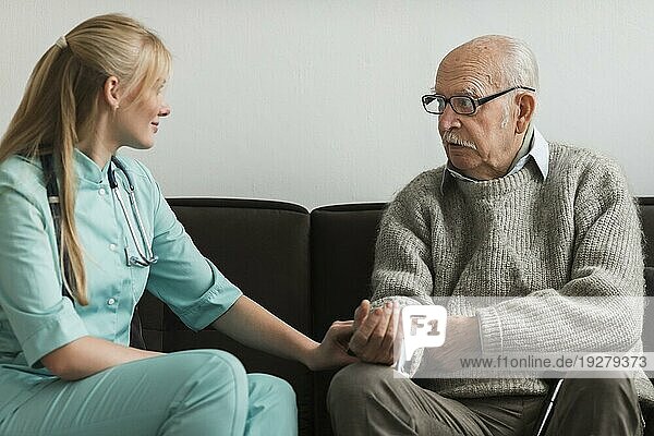 Krankenschwester tröstet alten Mann im Pflegeheim
