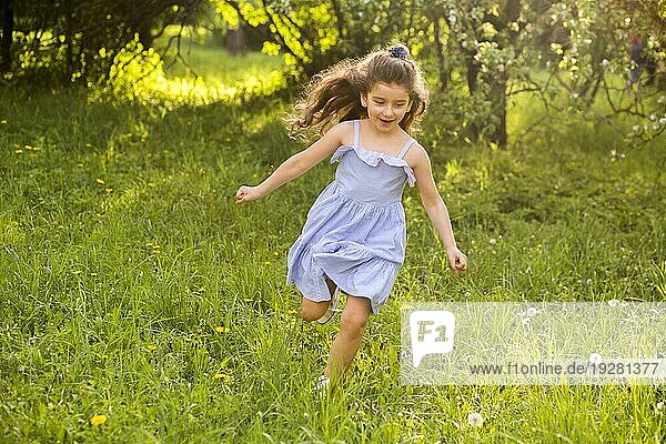 Niedliches kleines Mädchen läuft im Garten