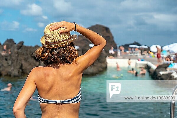 Der Badeort Porto Moniz  ein junges Touristenmädchen mit Hut und Bikini an den natürlichen Pools  Madeira