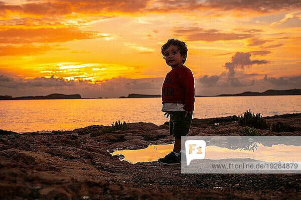 Sonnenuntergang auf Ibiza im Urlaub  ein einjähriger Junge hat Spaß am Meer in San Antonio Abad