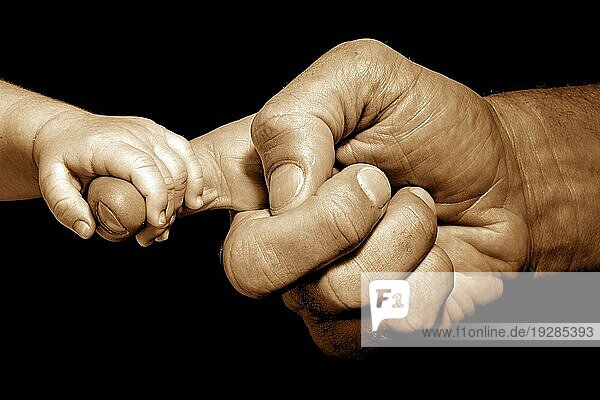 Händchenhalten des Babys durch einen Erwachsenen